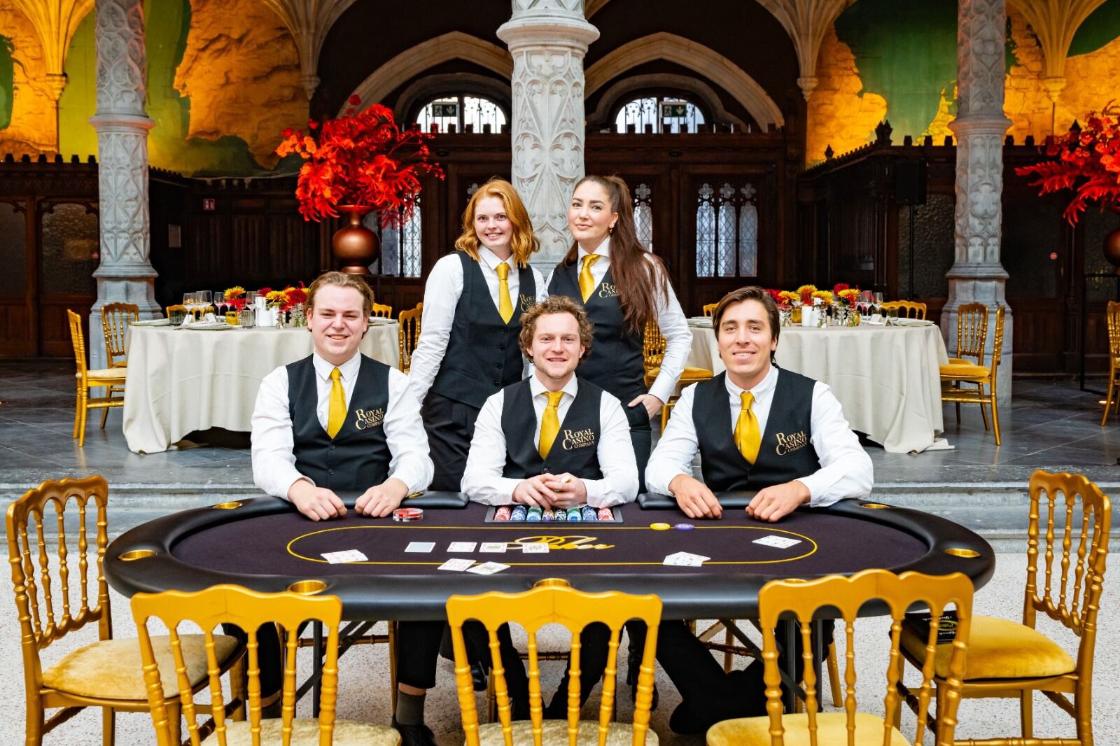 Luxe pokertafel met gouden stoelen met achter de tafel 5 croupiers