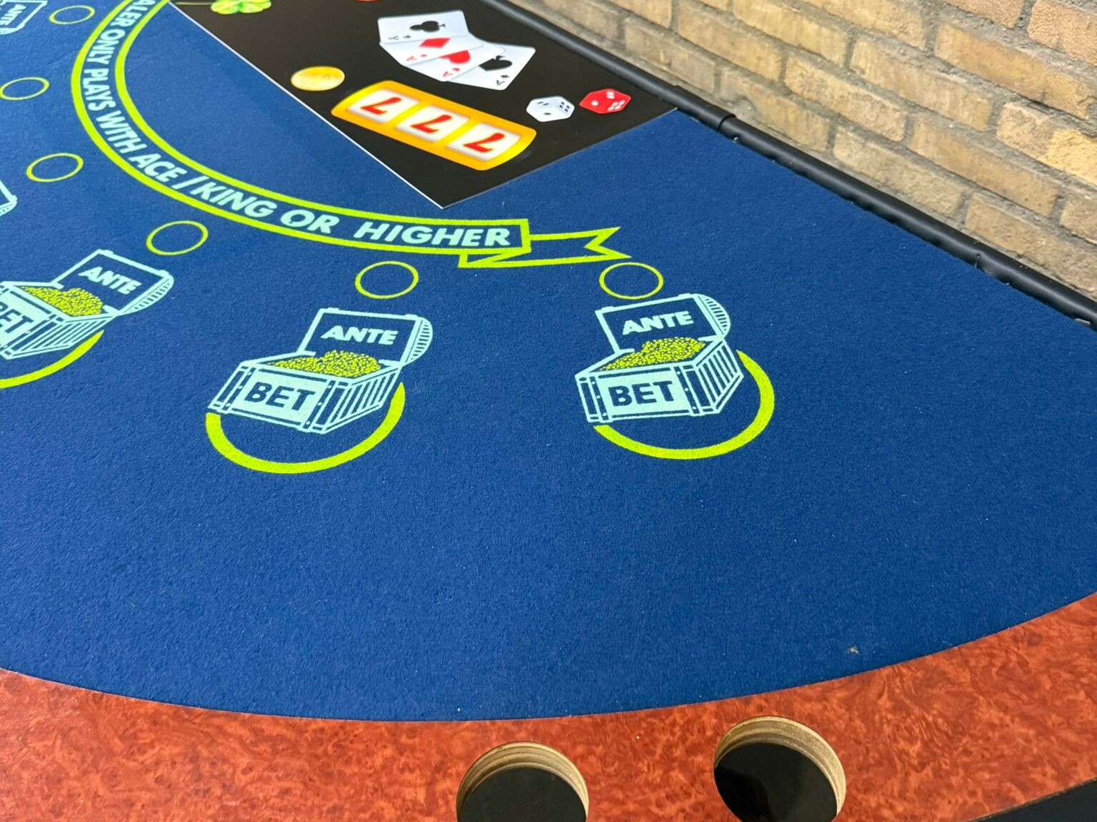 Detailfoto van tweedehands blackjacktafel met blauw speelveld en bedrukt inzetvlak.