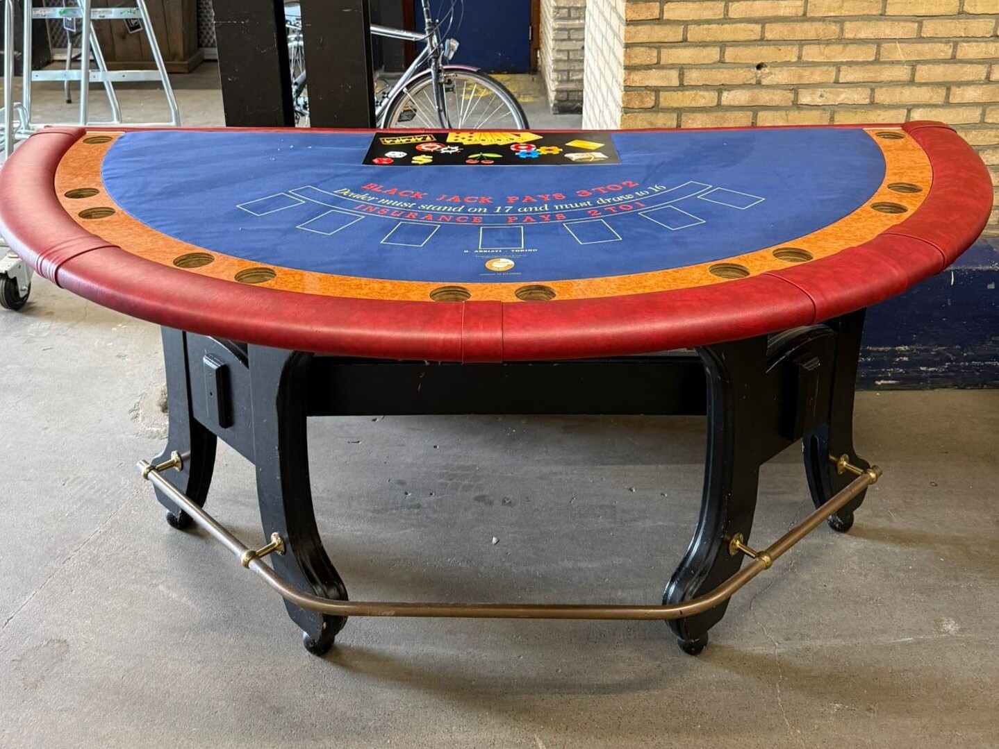 Royale tweedehands blackjacktafel uit casino verhuur, compleet met rode skyleren rand, houten onderstel en blauw speelveld.